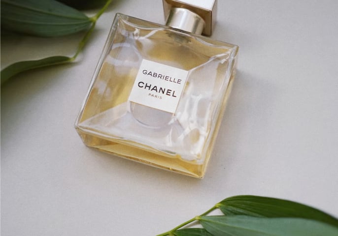 Bottle of Chanel Gabrielle Essence Eau De Parfum on a floral background